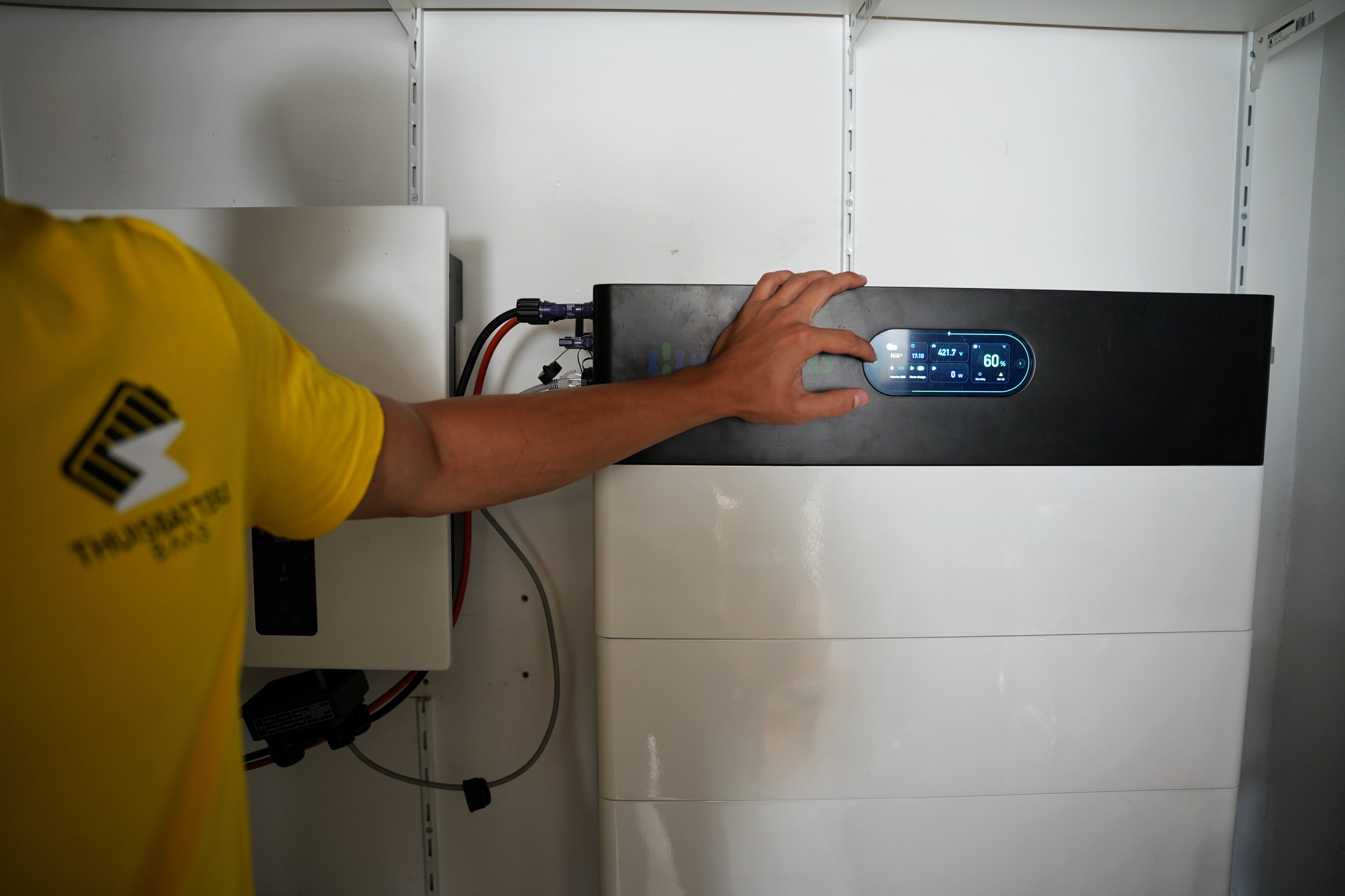 Installateur naast een slimme thuisbatterij.